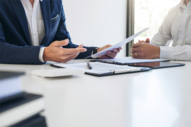 Close-up view of an agent discussing the benefits of a surety bond with a business insurance customer.